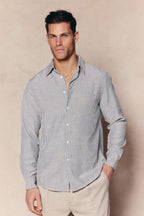 Man wearing an Abilo Ecru/Navy striped shirt with an open collar, chest pocket, and light trousers.