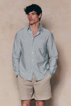 Man in tailored Abilo Khaki/Ecru striped shirt with open collar and chest pocket, paired with beige shorts.