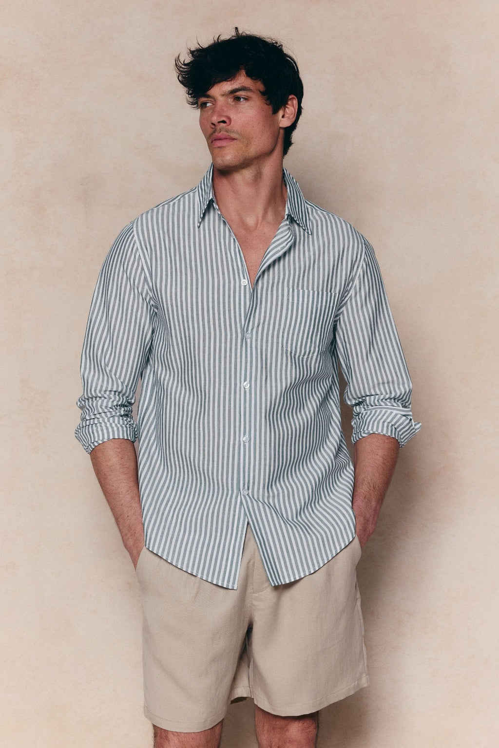Man wearing an Abilo Striped Shirt in khaki/ecru with an open collar, chest pocket, and tailored fit.