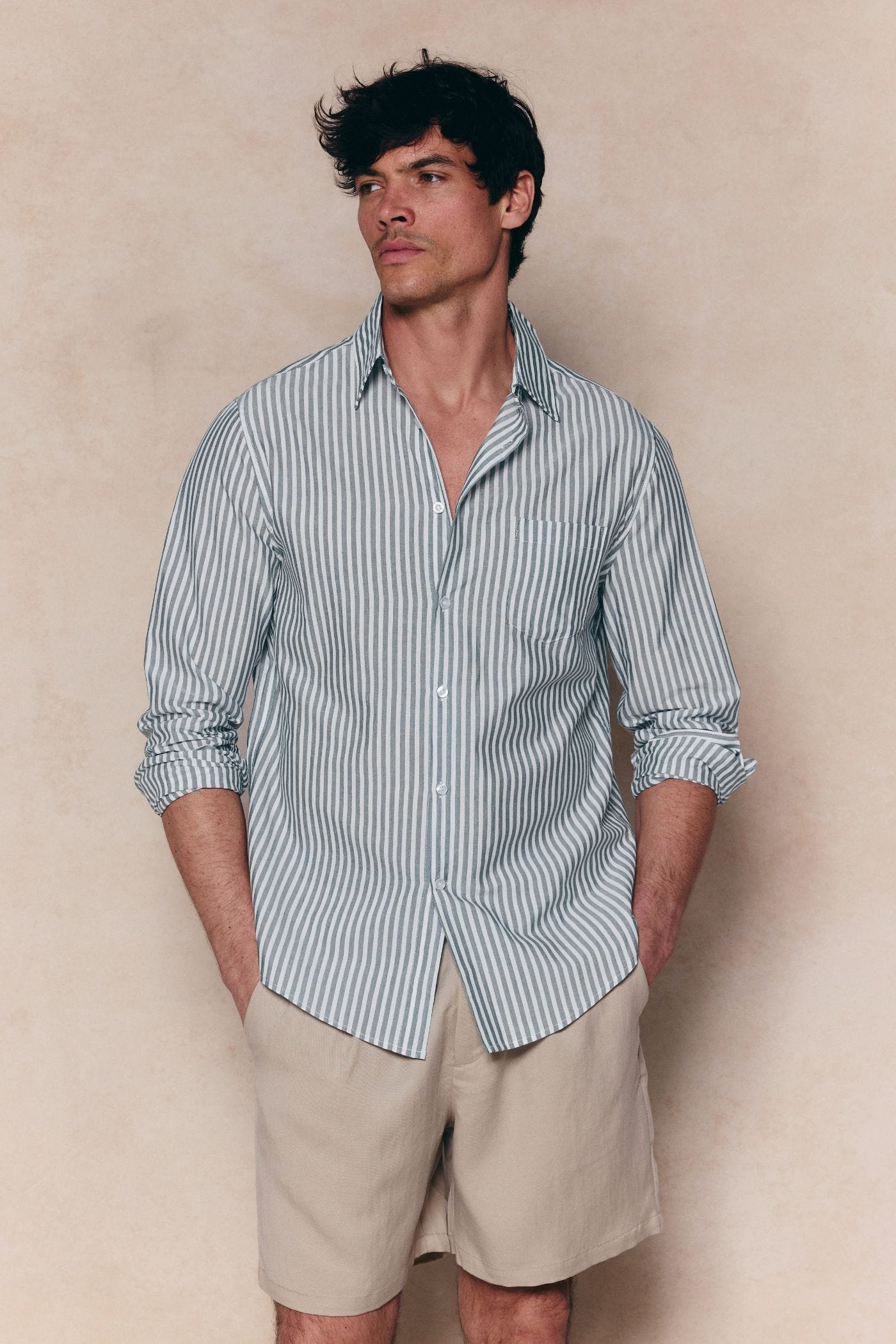 Man wearing an Abilo Striped Shirt in khaki/ecru with an open collar, chest pocket, and tailored fit.