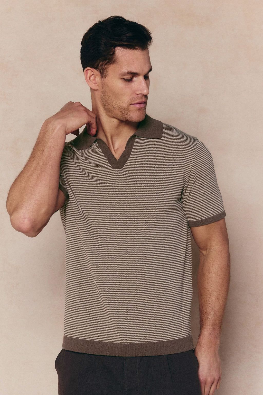 Man in Antonio brown/beige striped linen polo with open collar and contrast trim.
