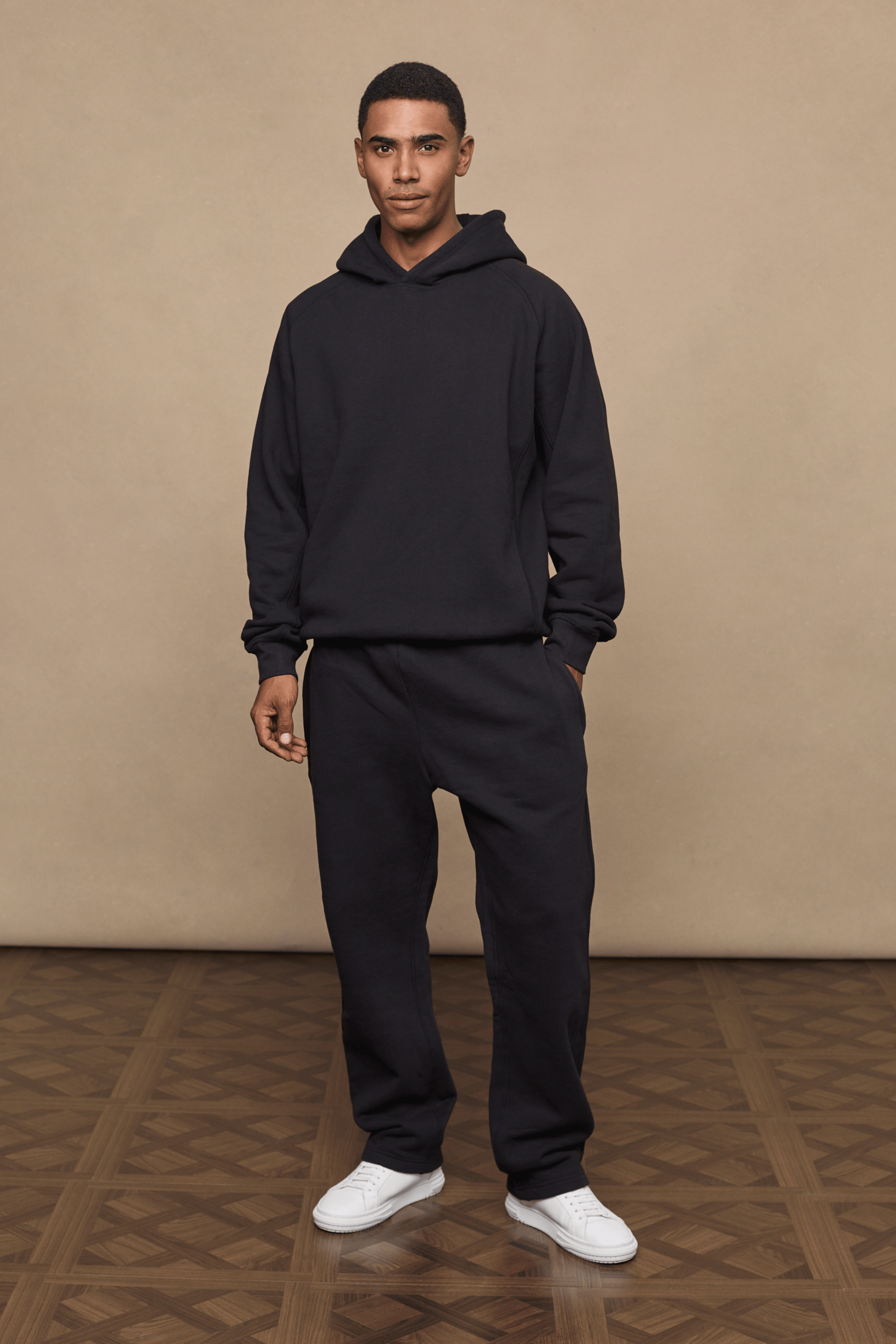 Man wearing black Axel straight leg joggers and matching hoodie, made from heavyweight cotton-blend fleece.
