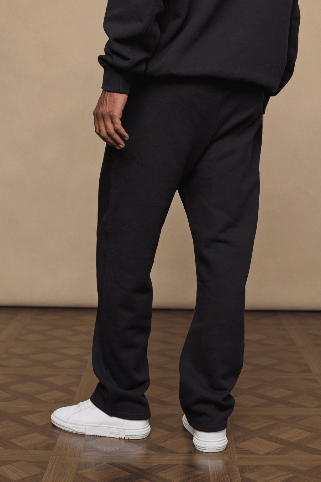 Black Axel straight leg joggers made from heavyweight cotton-polyester blend, paired with a matching hoodie and white sneakers.