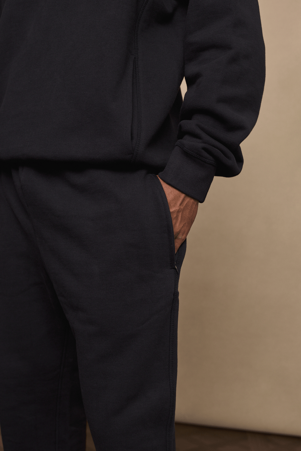 Black Axel straight leg jogger and matching hoodie, crafted from heavyweight fleece, with a hand in the side pocket.