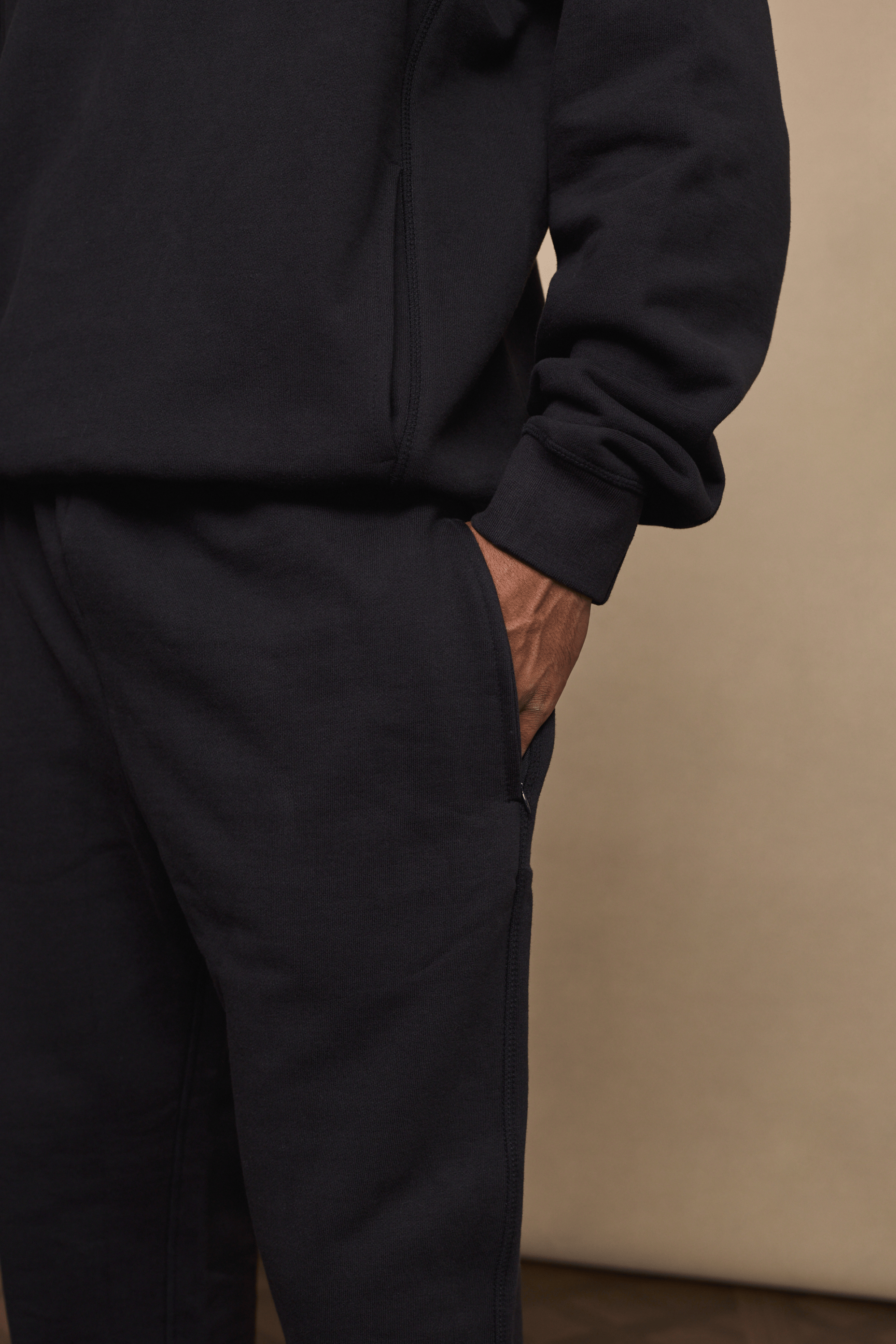 Black Axel straight leg jogger and matching hoodie, crafted from heavyweight fleece, with a hand in the side pocket.