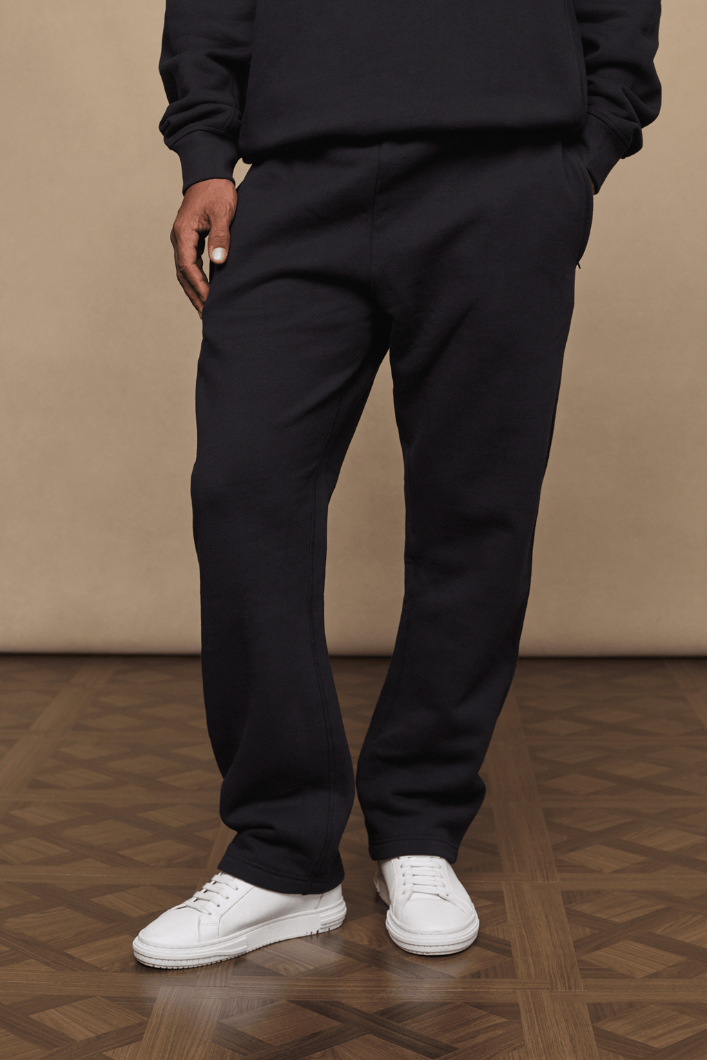 Black Axel straight leg joggers made from heavyweight cotton-polyester blend, worn with white sneakers.