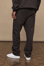 Dark brown Axel straight leg joggers made from heavyweight cotton-polyester blend, worn with white sneakers.