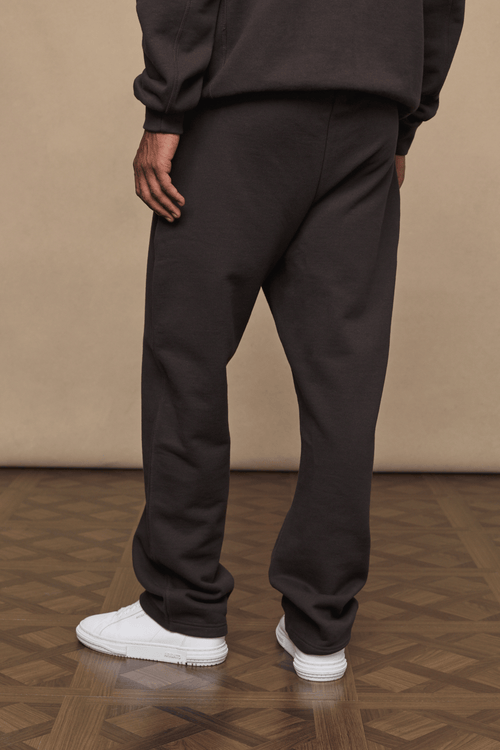 Dark brown Axel straight leg joggers made from heavyweight cotton-polyester blend, worn with white sneakers.