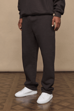 Dark brown Axel straight leg jogger and matching hoodie on a person, paired with white sneakers.