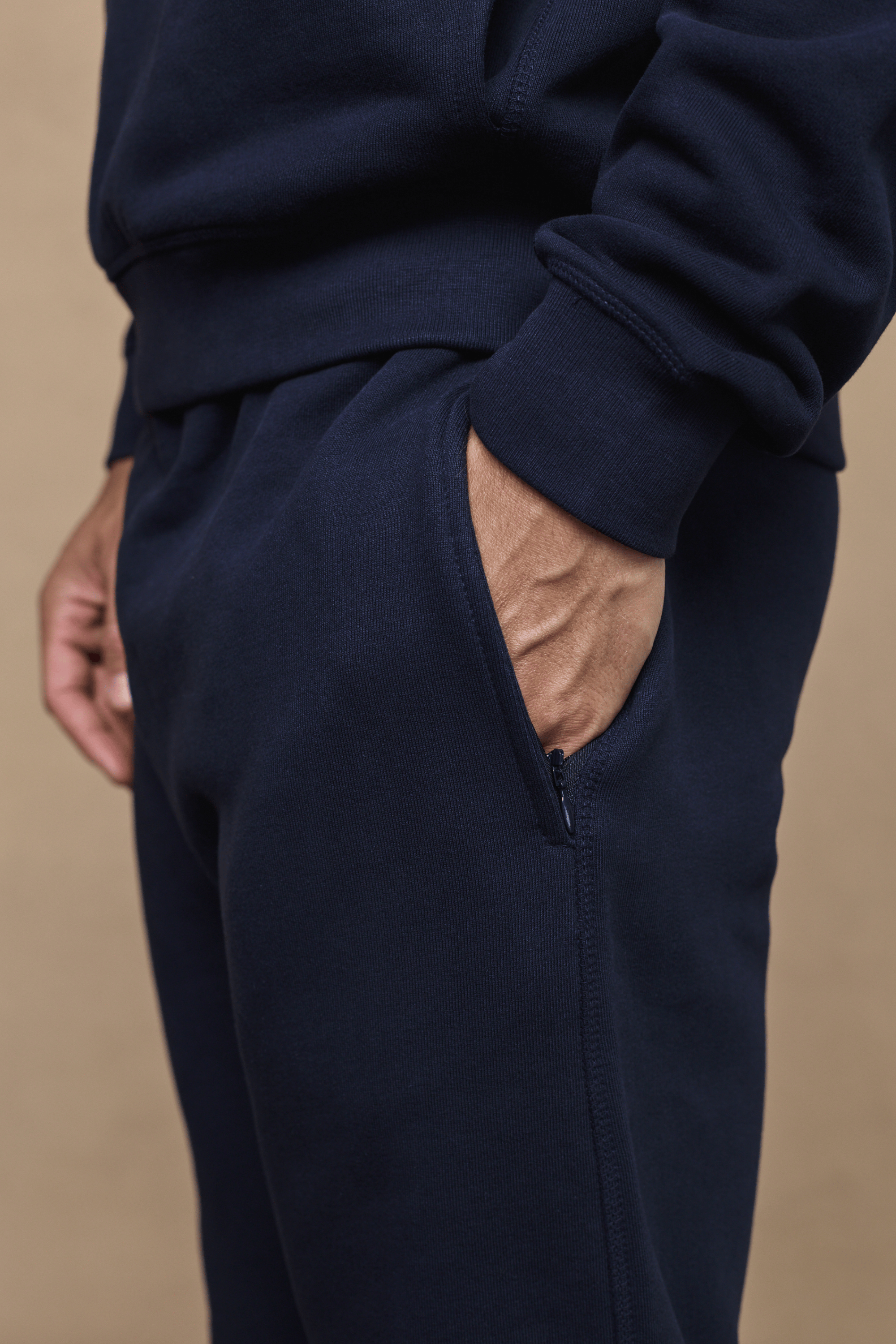 Dark navy Axel straight leg jogger with a hand in the discreet side pocket.