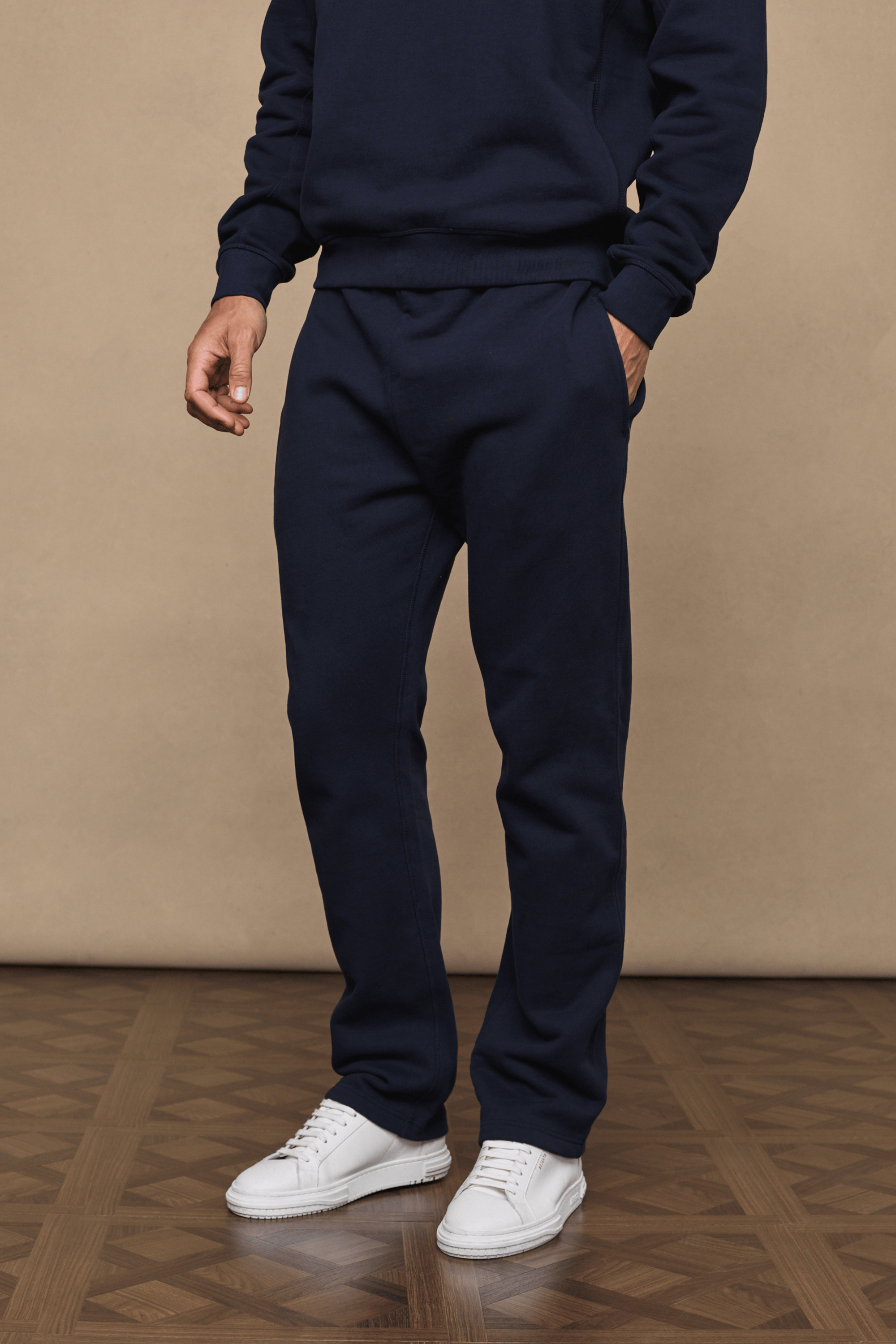 Dark navy Axel straight leg joggers made from heavyweight cotton-polyester fleece, worn by a person with white sneakers.