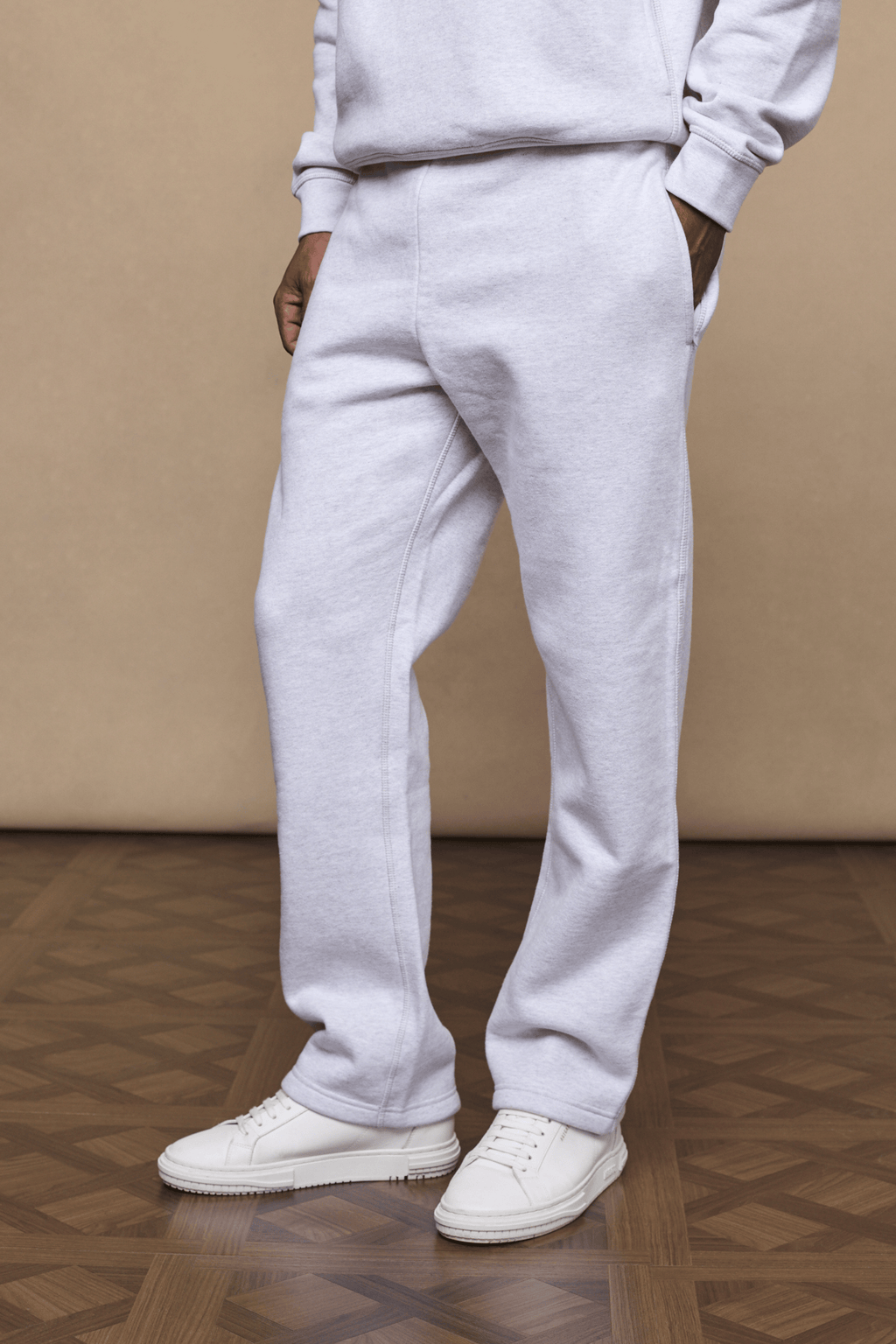 Axel straight leg jogger in stone marl, made from a heavyweight cotton-polyester blend, worn with white sneakers.