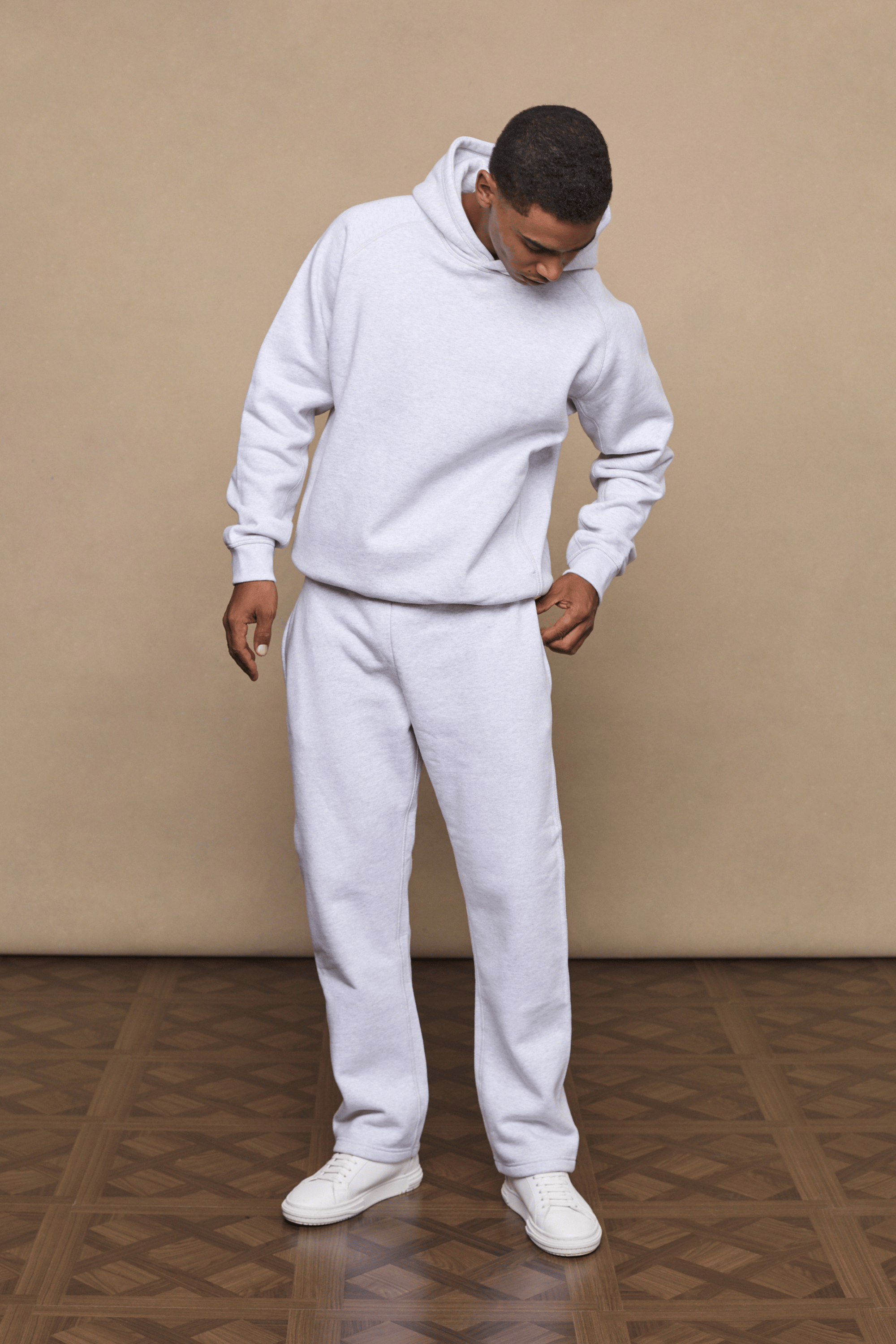 Man wearing a stone marl Axel straight leg jogger and matching hoodie, with white sneakers.
