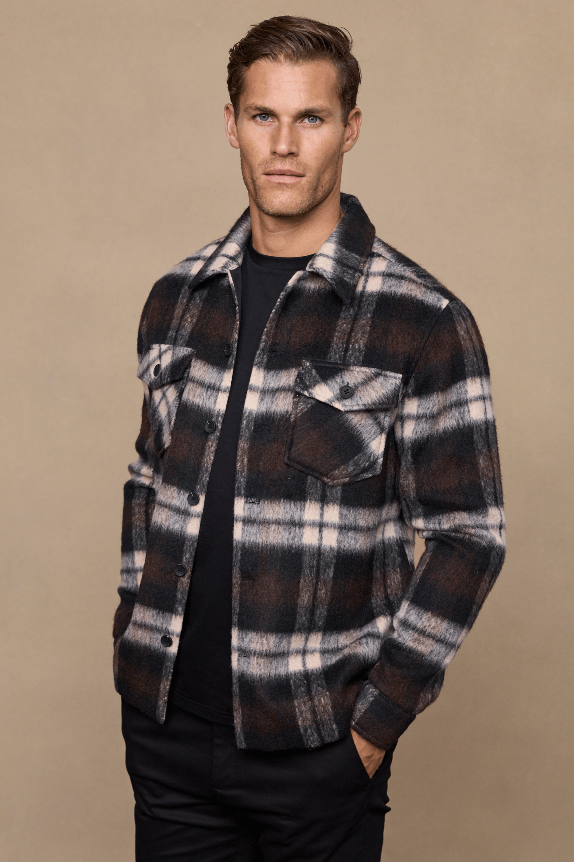Man wearing a brown/beige Caldera Brushed Wool Checked Jacket with twin chest pockets over a black t-shirt.