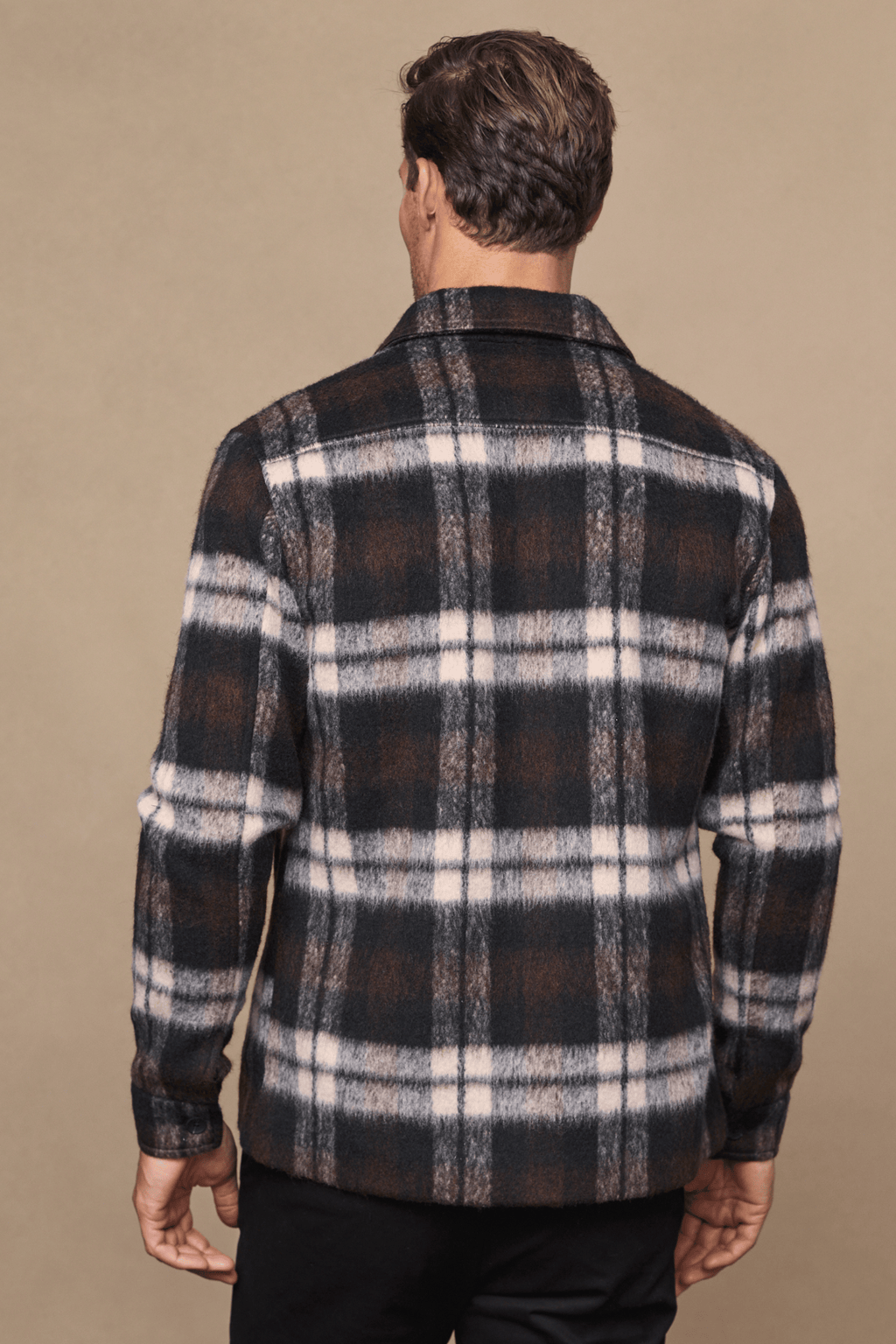 Man from behind wearing a brown, beige, and white brushed wool checked jacket with a point collar.