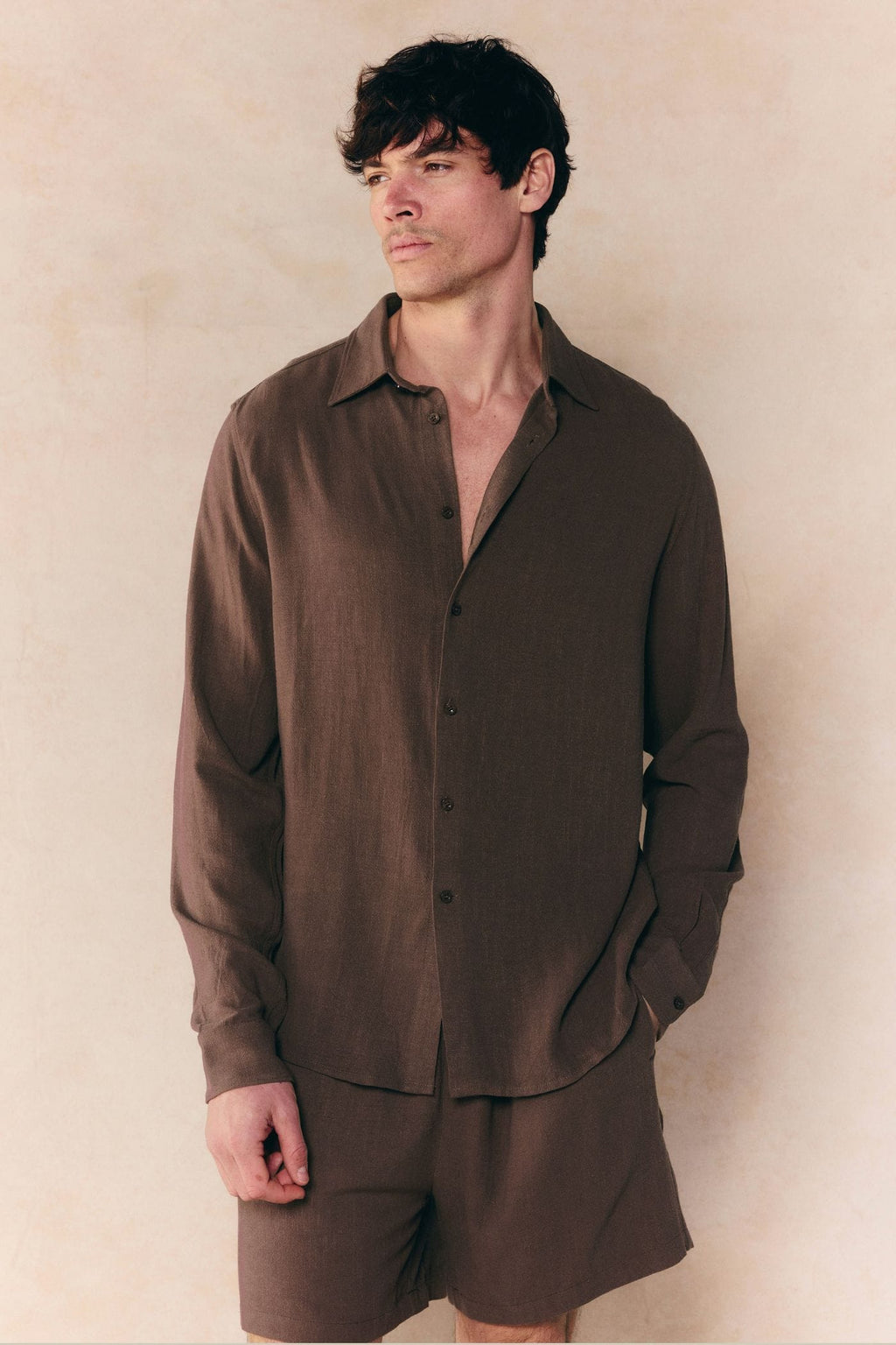 Man in a relaxed fit brown linen classic collar shirt and matching shorts.