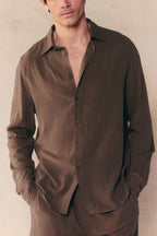 Man wearing a brown Cami Linen Classic Collar Shirt with long sleeves, relaxed fit, and open top button.