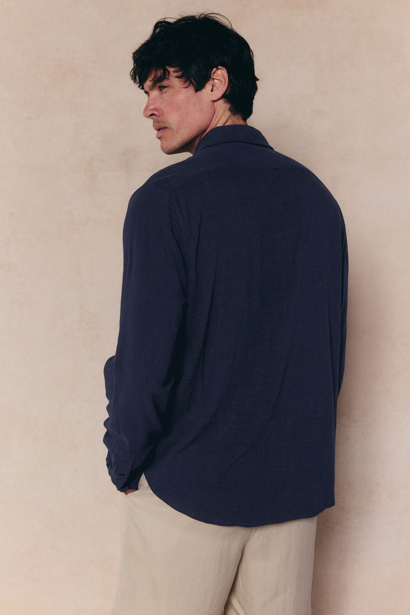 Man wearing a navy Cami Linen Classic Collar Shirt with a relaxed fit, natural texture, and standard collar.