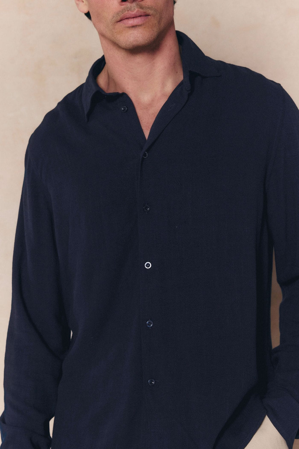 Man wearing a navy Cami Linen Classic Collar Shirt with a relaxed fit and natural texture.