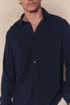 Man wearing a navy Cami Linen Classic Collar Shirt with a relaxed fit and natural texture.