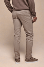 Man wearing beige Elliot Easy Chino trousers with a modern silhouette and brown suede sneakers.