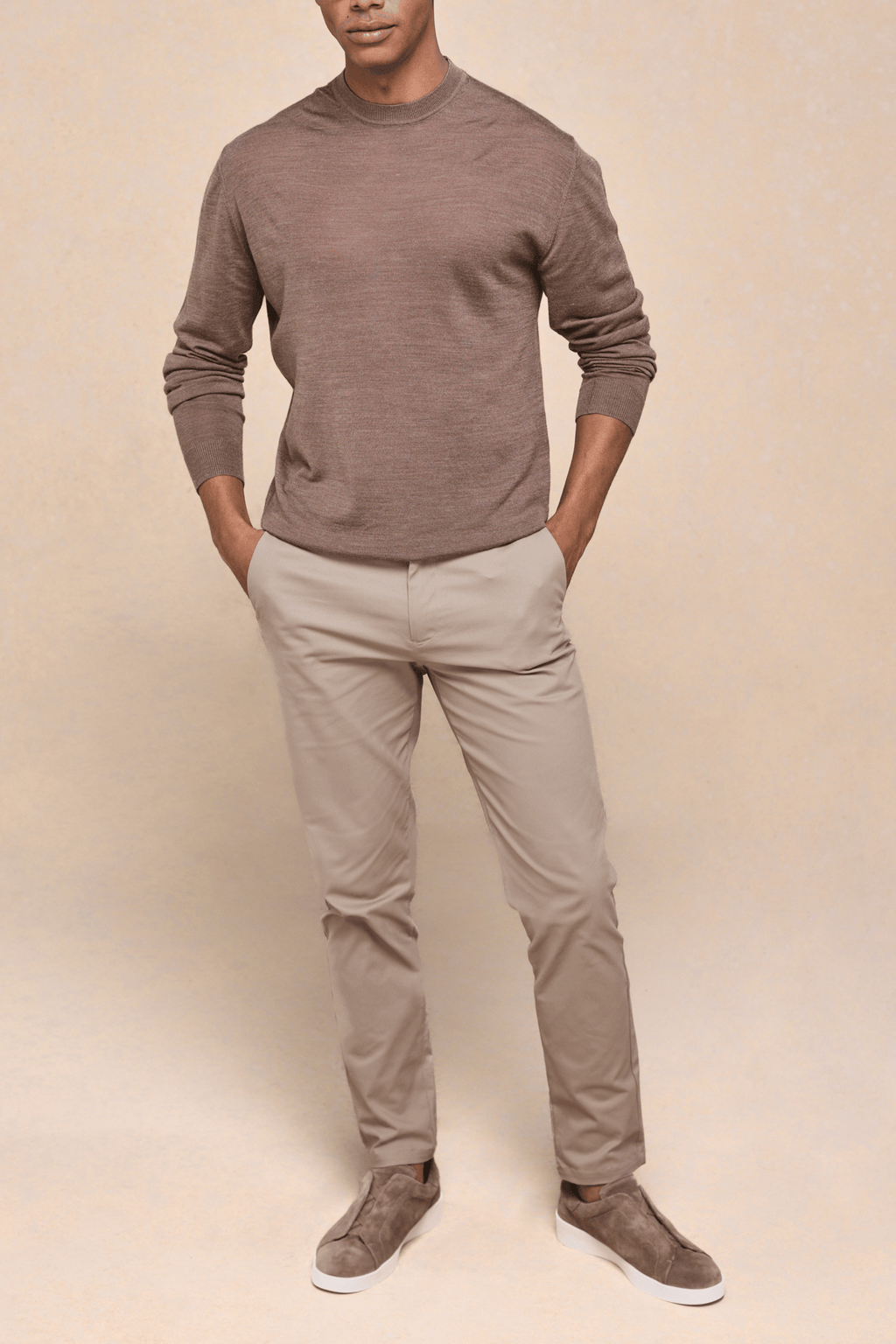 Man wearing beige Elliot Easy Chino pants with a brown long-sleeve top and matching suede shoes.