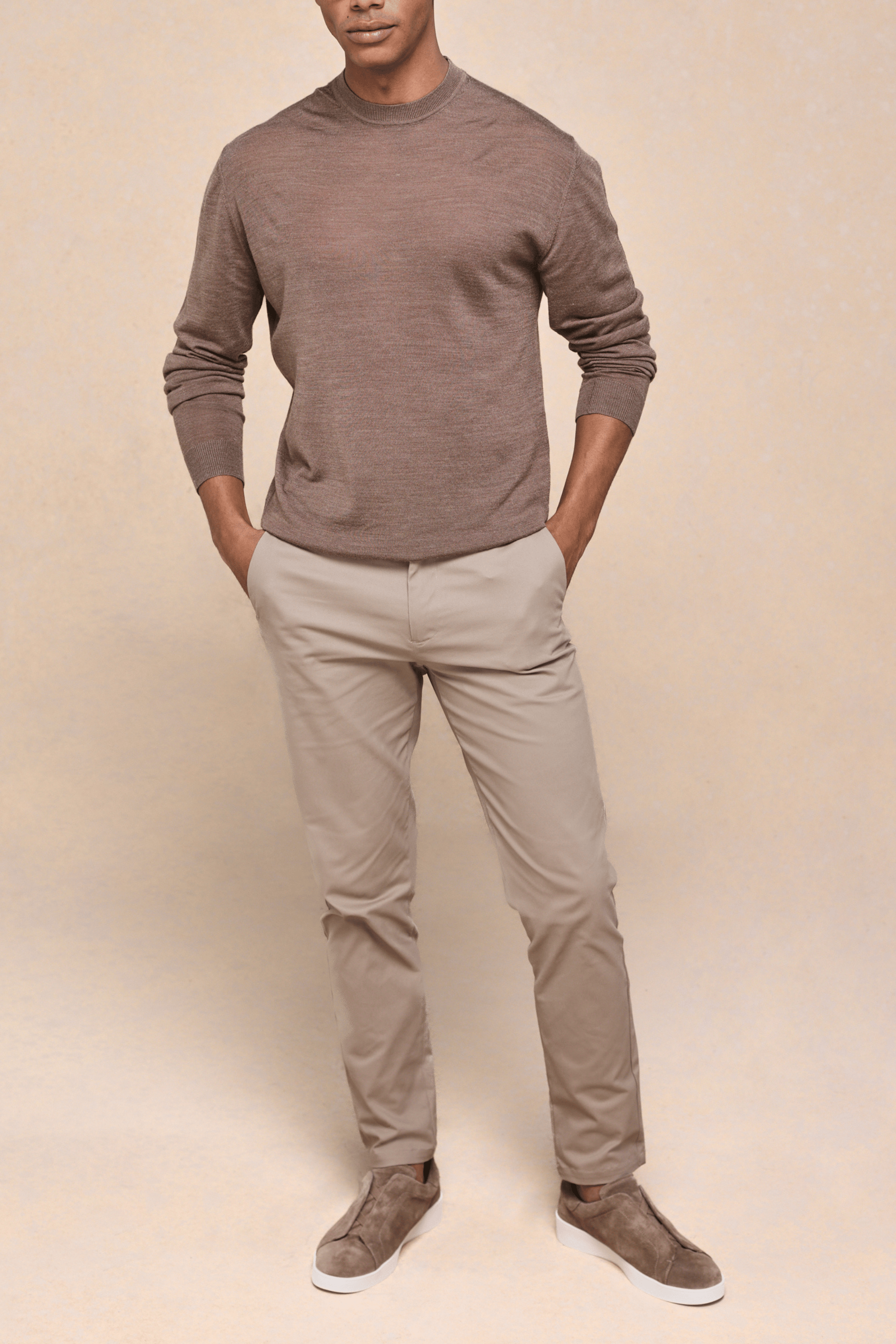 Man wearing beige Elliot Easy Chino pants with a brown long-sleeve top and matching suede shoes.
