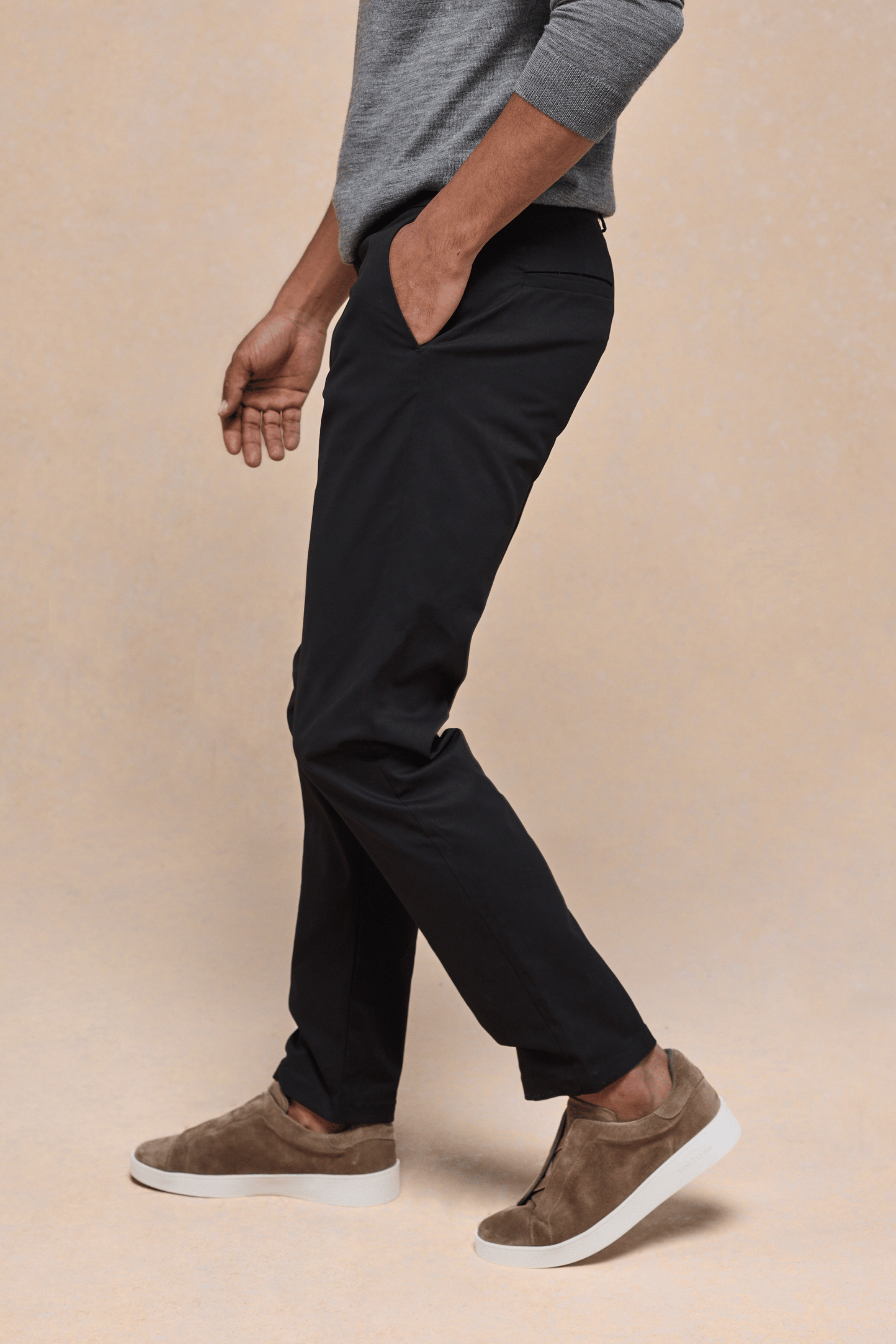 Man wearing black Elliot Easy Chino pants with a grey sweater and brown suede shoes.