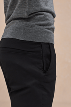 Black Elliot Easy Chino pants with side entry pockets, worn by a person in a grey sweater.