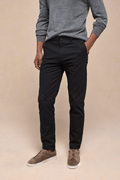 Man wearing black Elliot Easy Chino pants with a grey sweater and brown suede shoes.