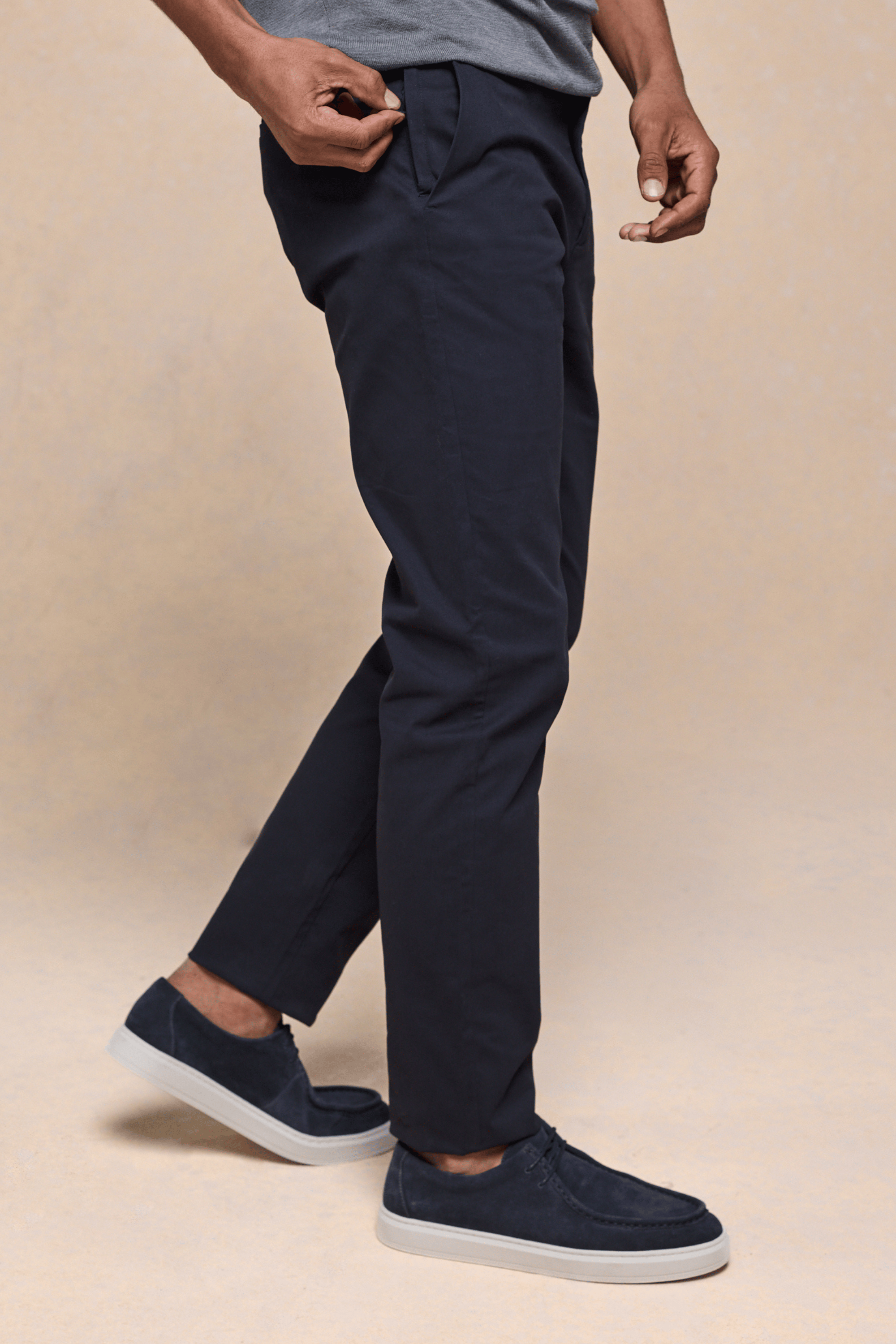 Man wearing dark navy Elliot Easy Chino pants with belt loops and side pockets, paired with navy suede shoes.