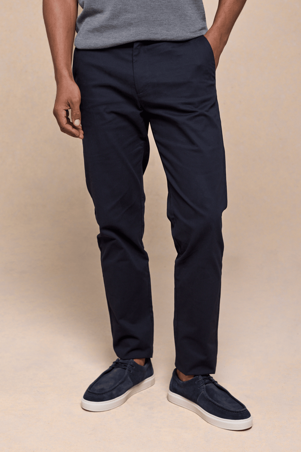 Dark navy Elliot Easy Chino pants with a modern silhouette, worn by a man with a grey shirt and blue shoes.