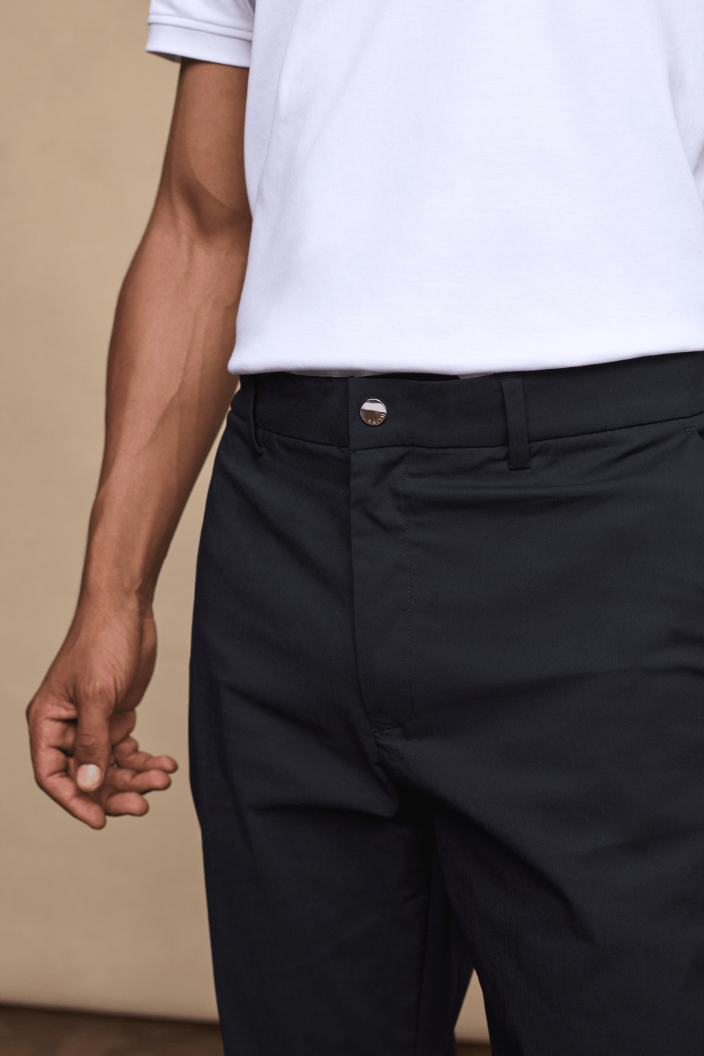 Close-up of black Enzo Hybrid Trousers made from lightweight 4-way stretch fabric, featuring a branded popper button.