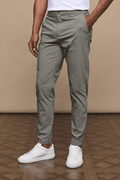 Man wearing dark olive Enzo Hybrid Trousers made from 4-way stretch fabric, with side pockets and belt loops.