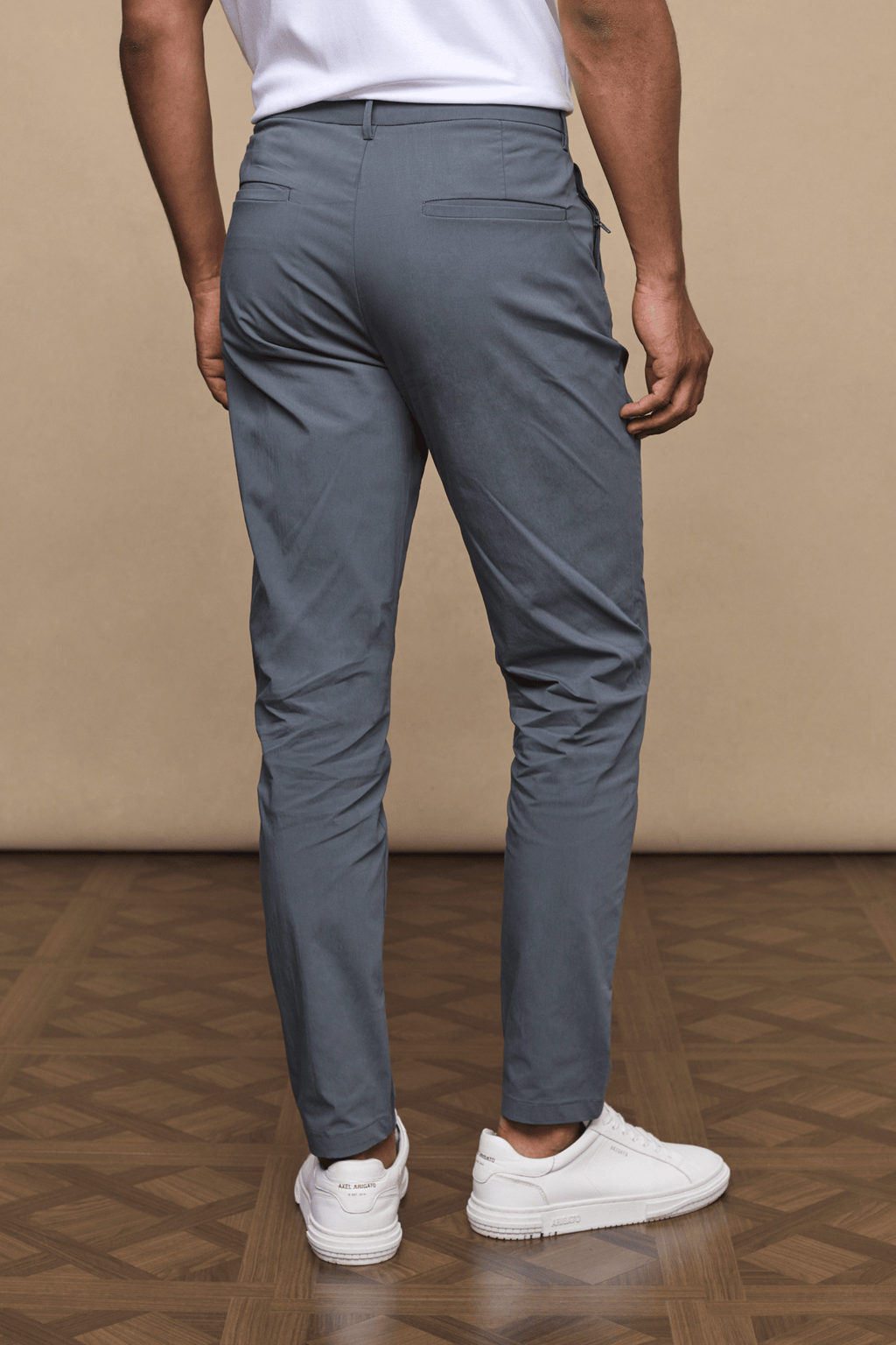 Man from behind wearing slate Enzo Hybrid Trousers made from lightweight 4-way stretch fabric.