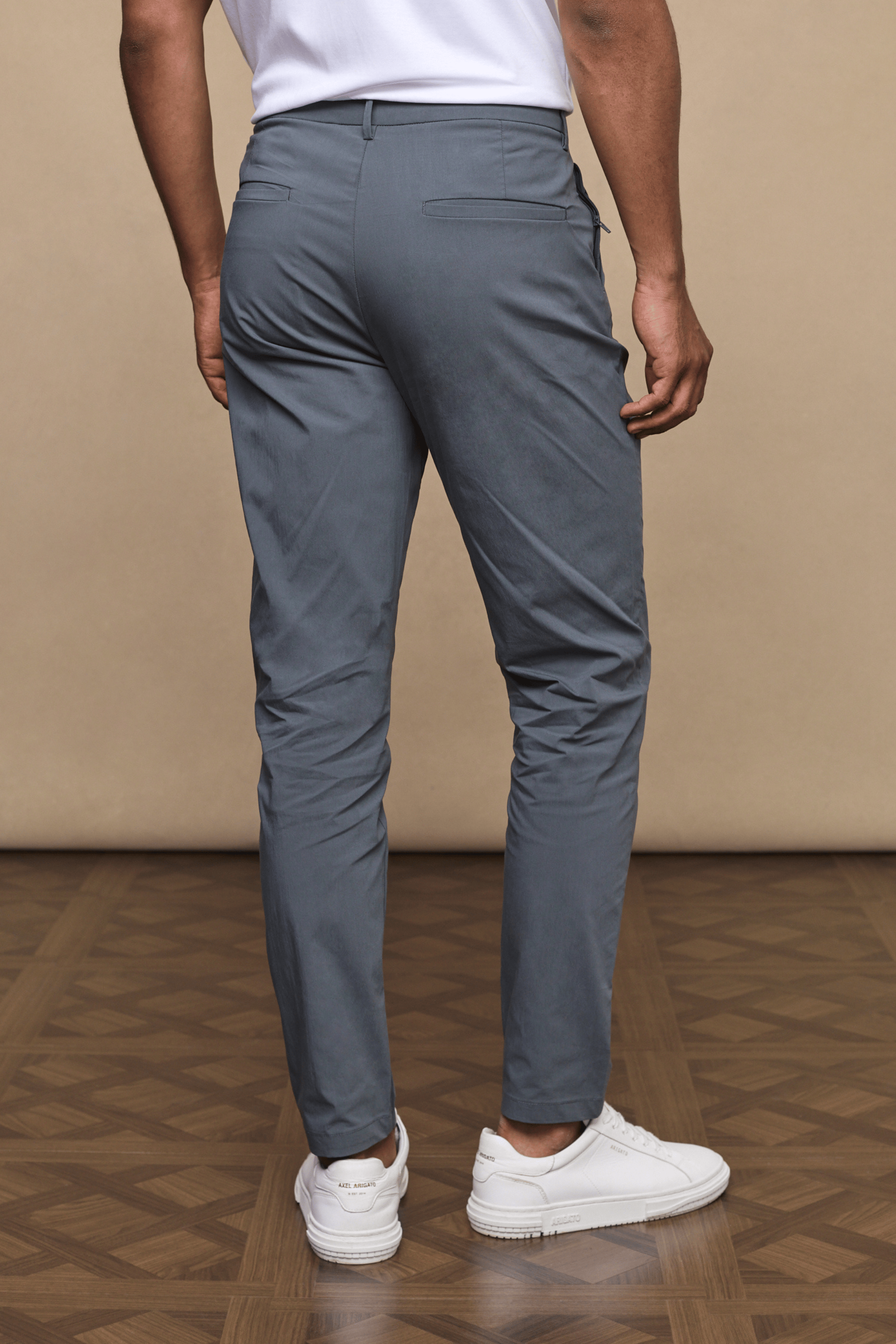 Man from behind wearing slate Enzo Hybrid Trousers made from lightweight 4-way stretch fabric.