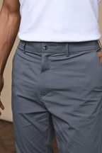 Close-up of Enzo Hybrid Trouser in slate, showing branded popper button, belt loops, and side entry pockets.