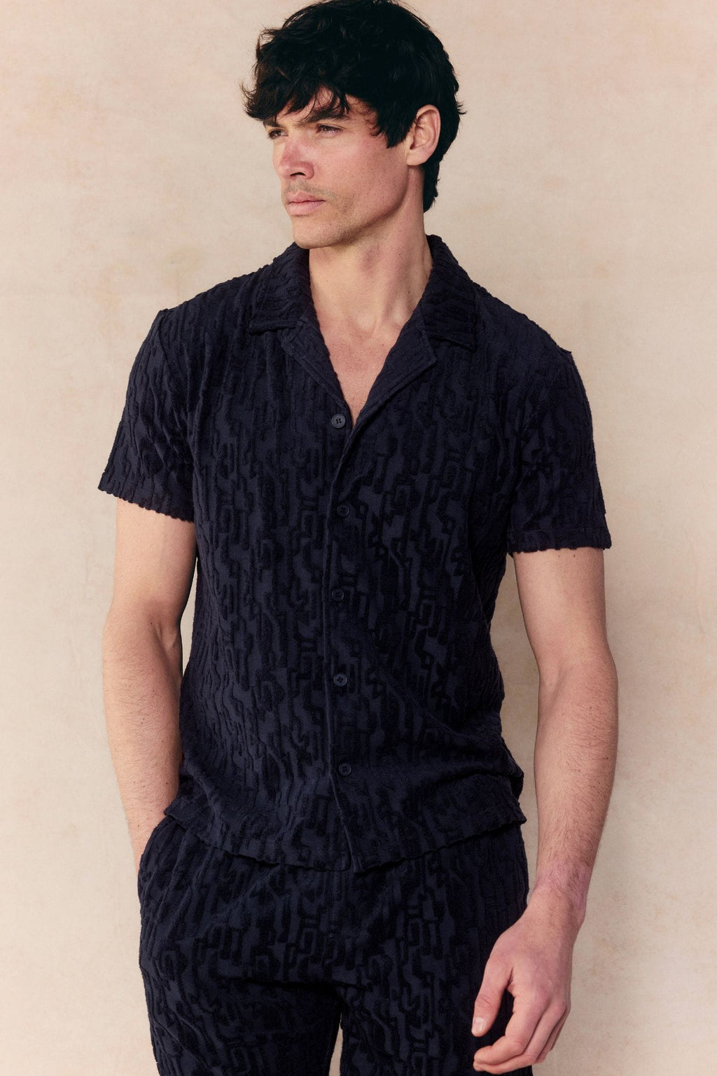 Man wearing a navy Fausto Flocked Top and matching shorts, featuring a unique textured towelling fabric.