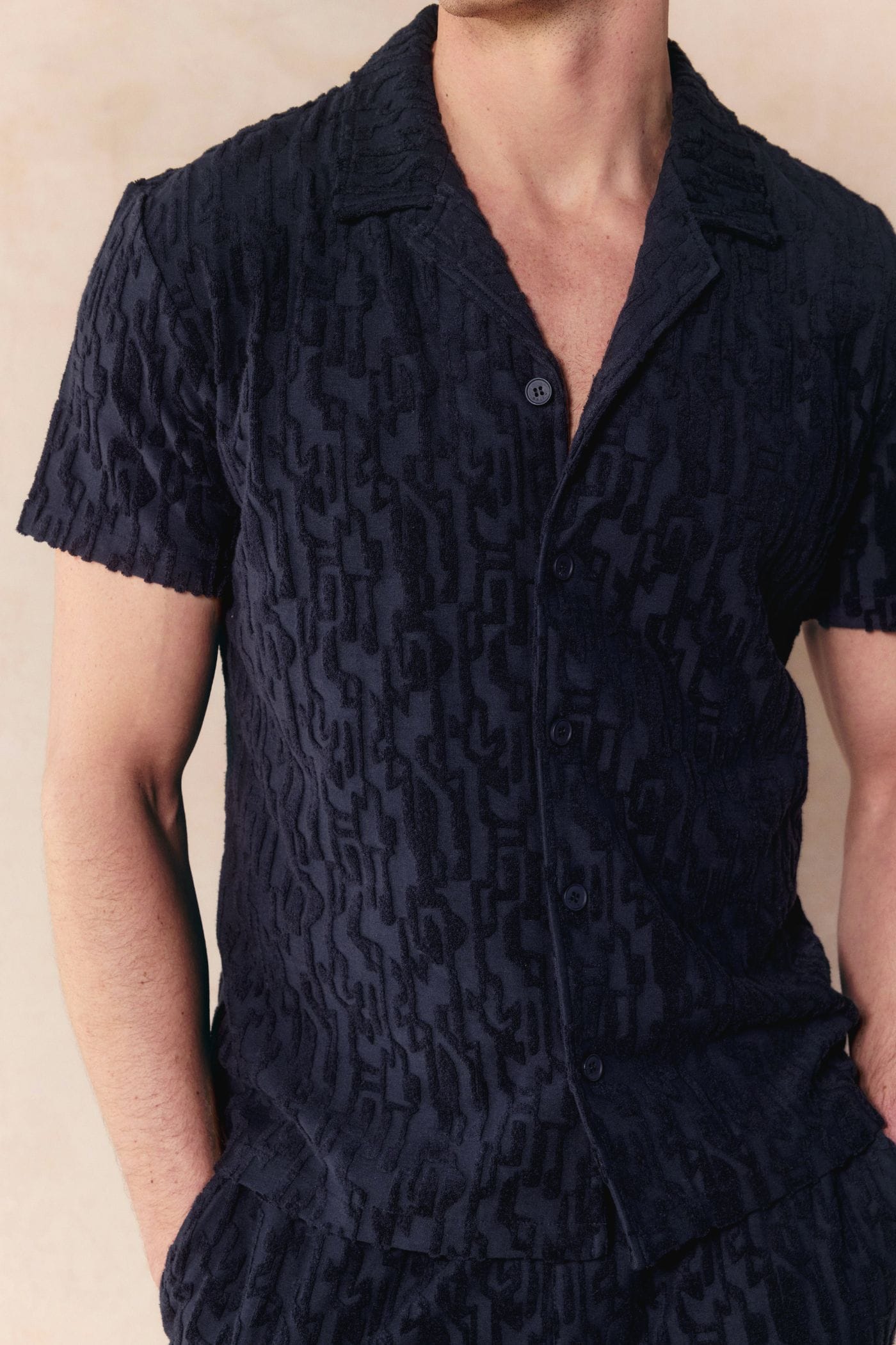 Navy Fausto Flocked Top, a short-sleeved towelling shirt with a unique textured pattern and open collar.