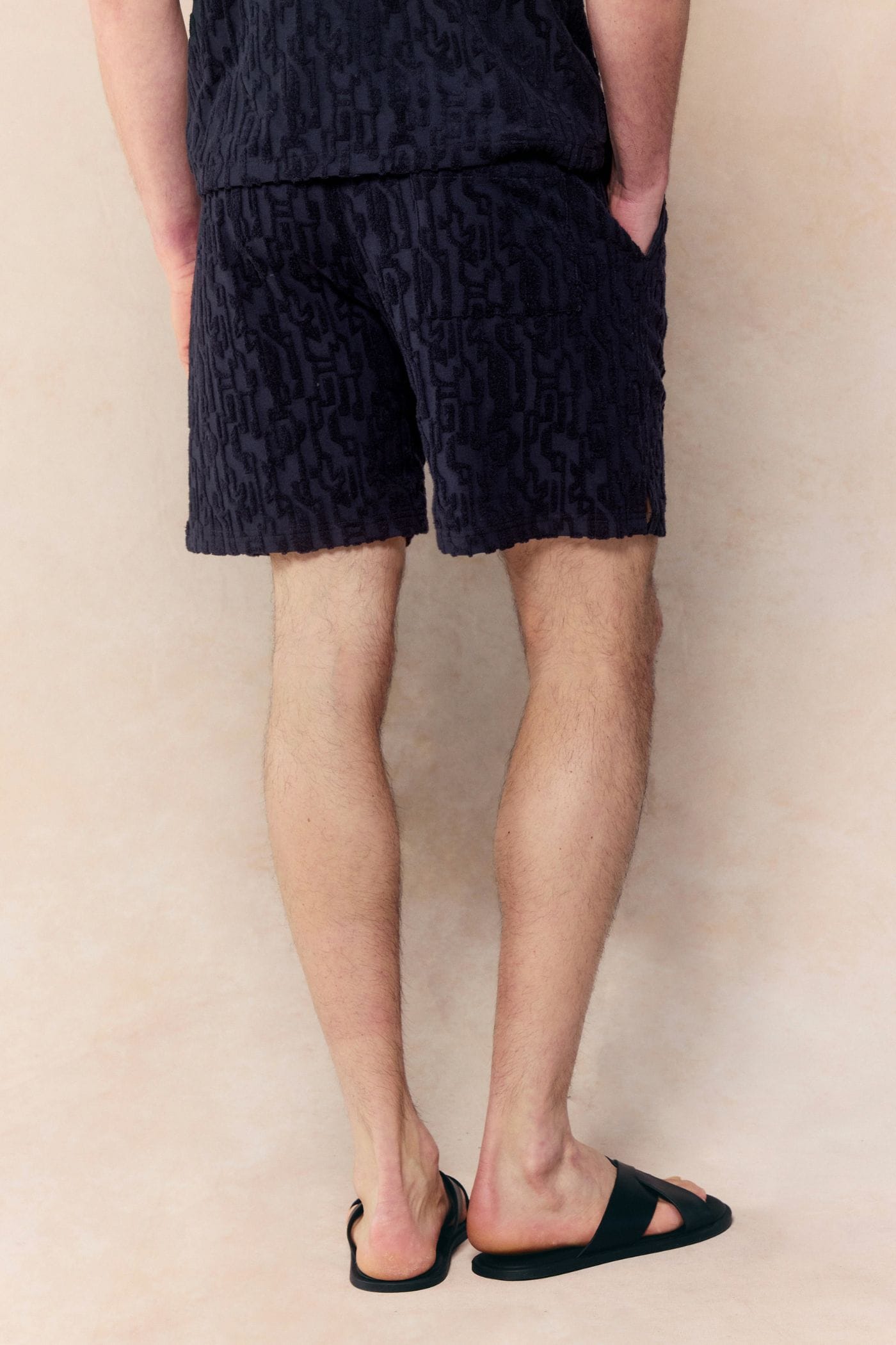 Navy Fausto Flocked Towelled Shorts with unique textured pattern, elasticated waistband, and side pockets on a male model.
