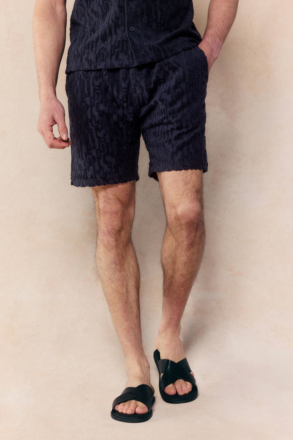 Navy Fausto Flocked Towelled Short with unique textured pattern, elasticated waistband, worn by a man.
