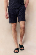 Navy Fausto Flocked Towelled Short with unique textured pattern, elasticated waistband, worn by a man.