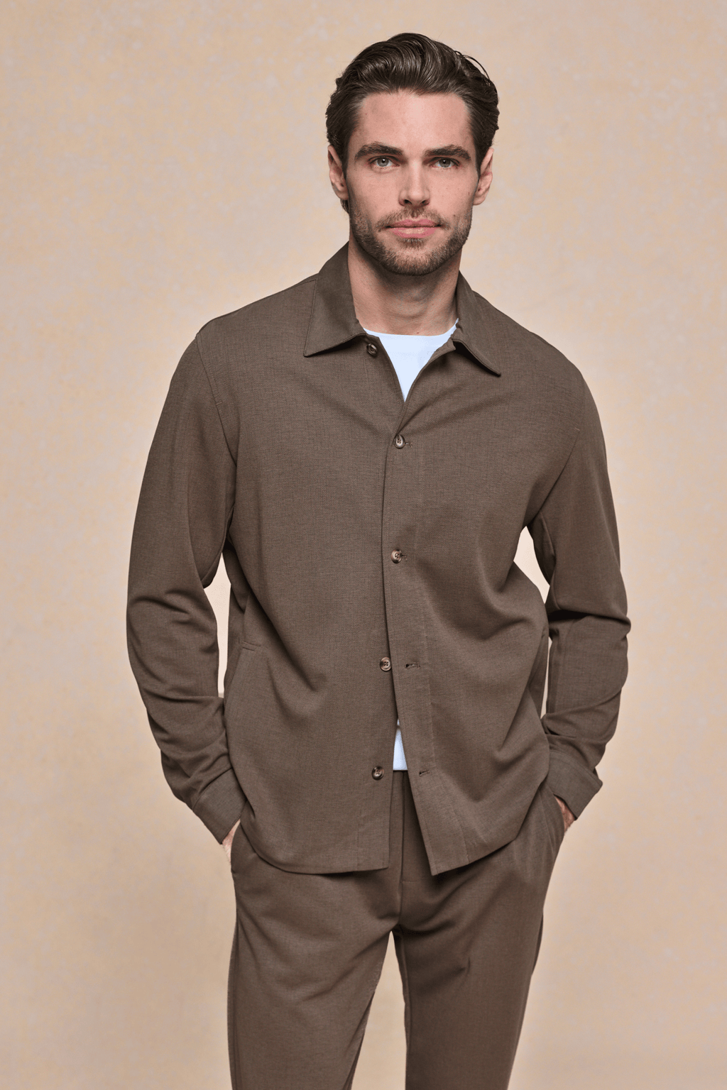 Man wearing a brown Geneva Textured Overshirt with a sharp collar, faux horn buttons, and matching trousers.