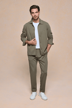 Man in khaki textured overshirt, white tee, matching trousers, and white sneakers.