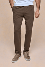 Men's brown textured tapered trousers with an elasticated waistband, side pockets, and a tailored fit.