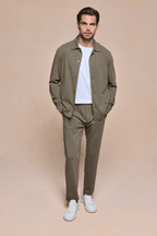 Man wearing a Khaki Geneva Textured Tapered Trouser and matching overshirt with a white t-shirt and white sneakers.