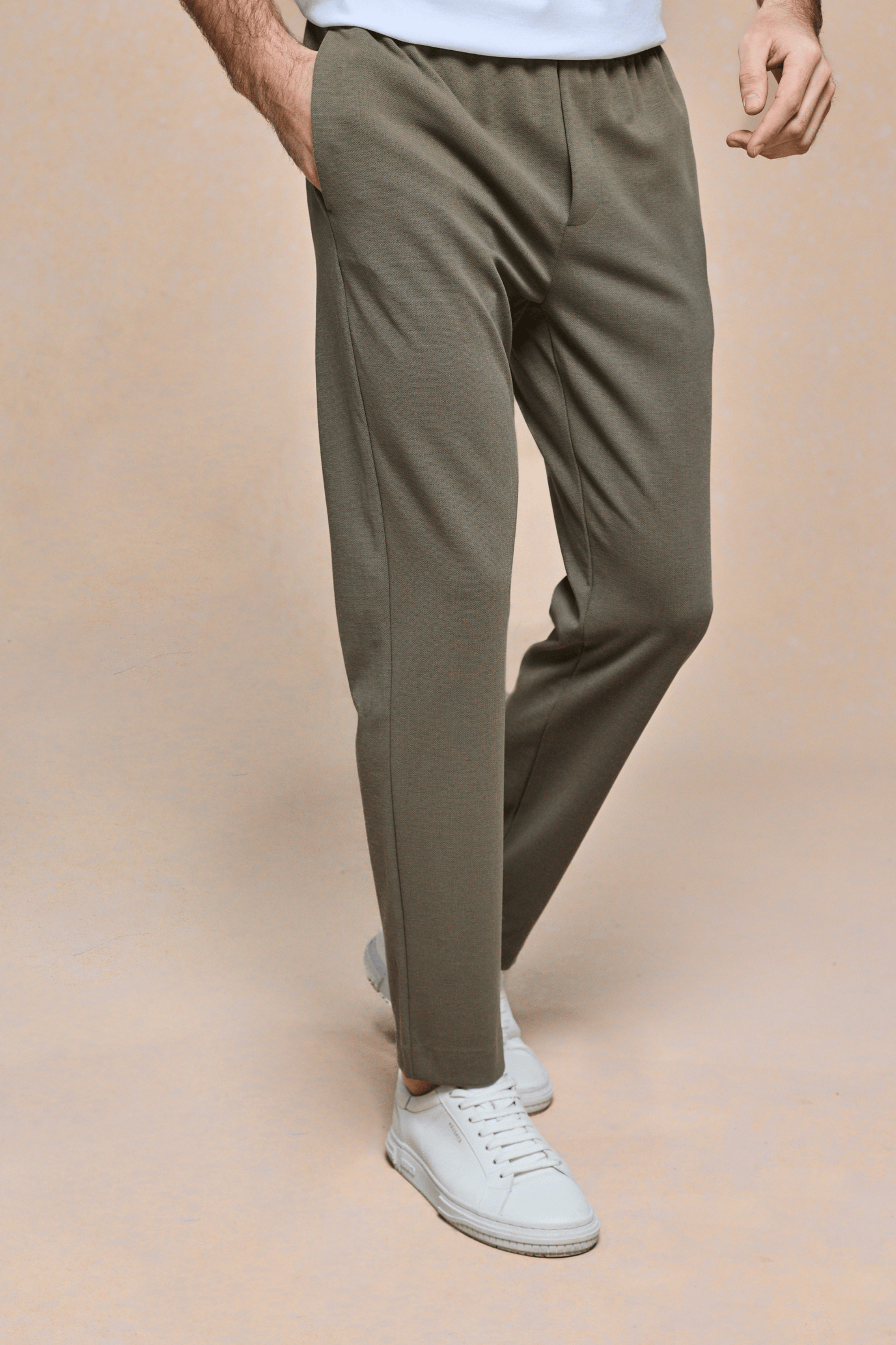 Men's Geneva Khaki Textured Tapered Trouser with elasticated waistband and side pockets, paired with white sneakers.