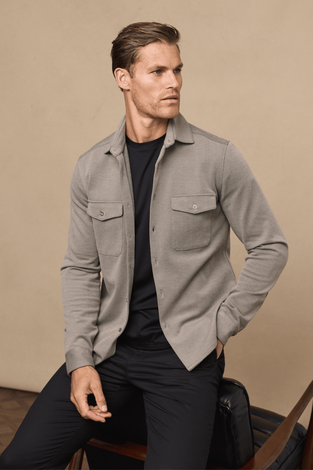 Man in beige/brown Jacques Textured Overshirt with twin chest pockets over a black t-shirt and trousers.