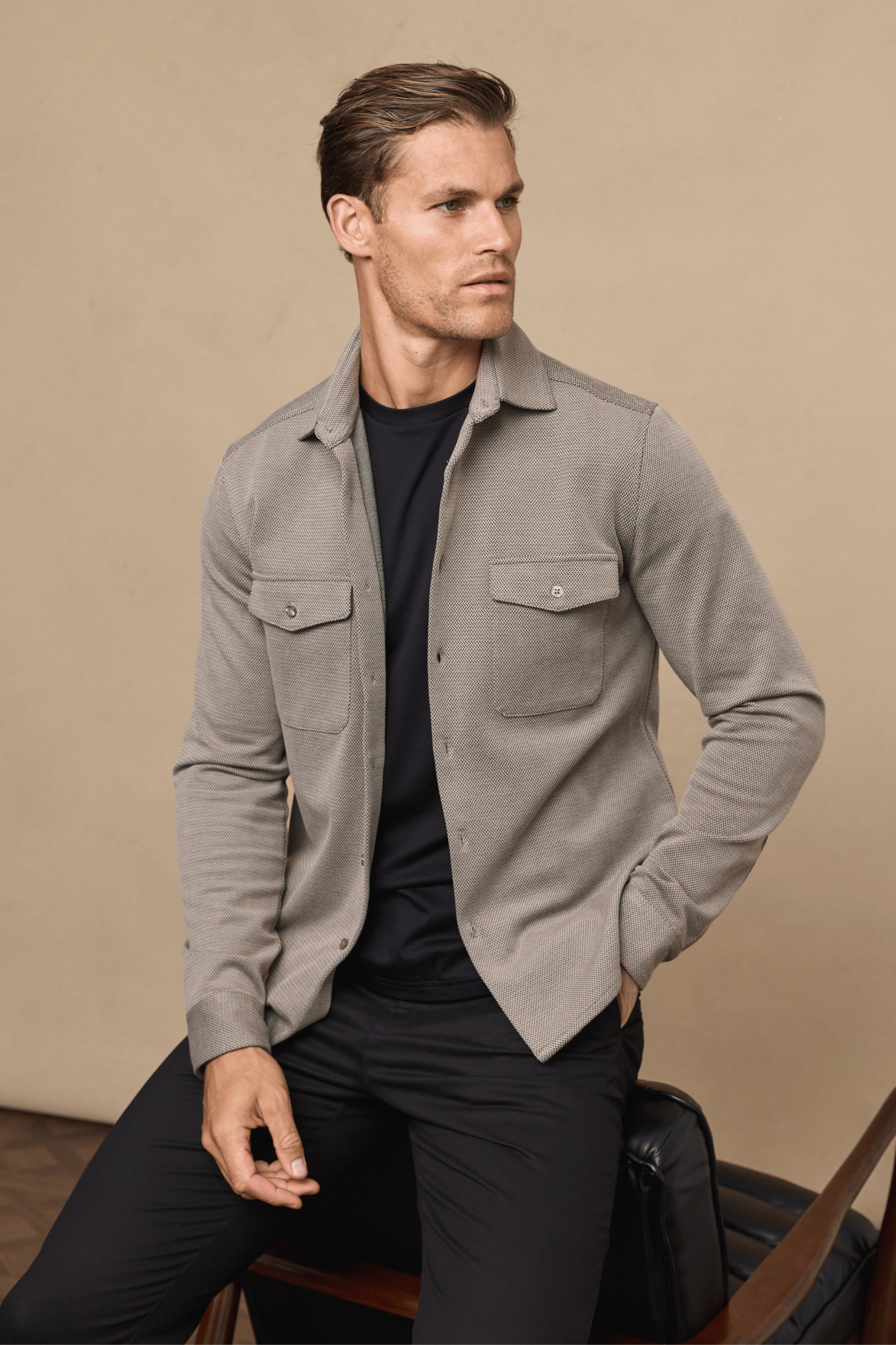 Man in beige/brown Jacques Textured Overshirt with twin chest pockets over a black t-shirt and trousers.