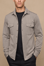 Man wearing a beige/brown textured overshirt with twin chest pockets over a black t-shirt.